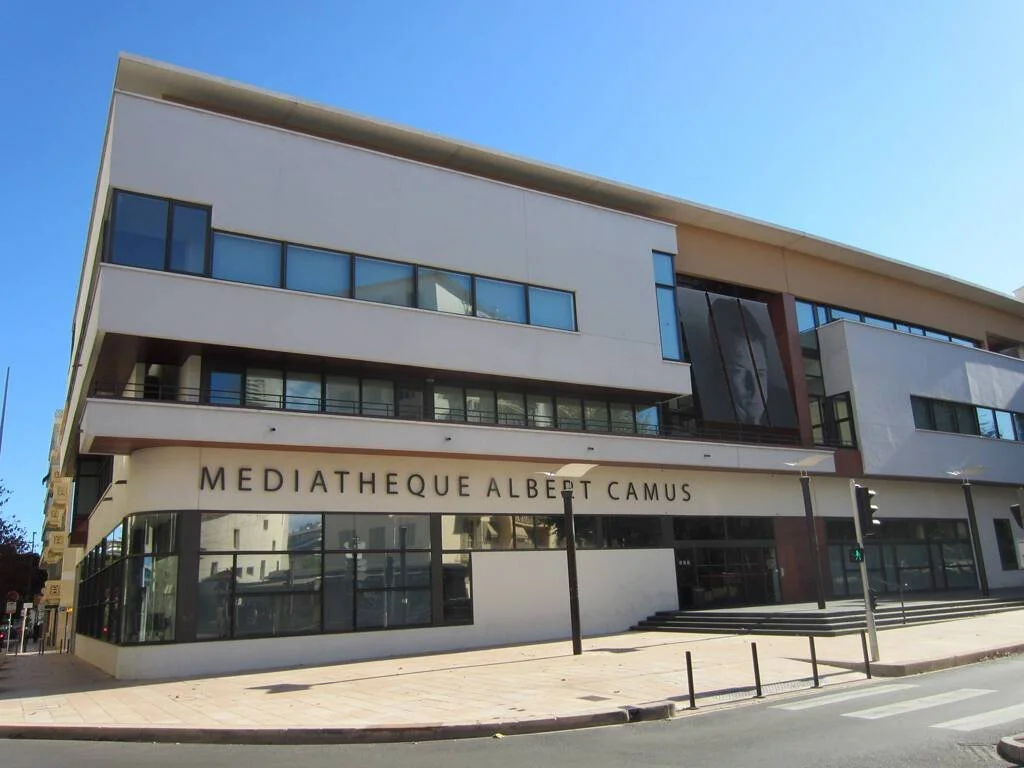Modern white library building with the sign Mediatheque Albert Camus under a blue sky