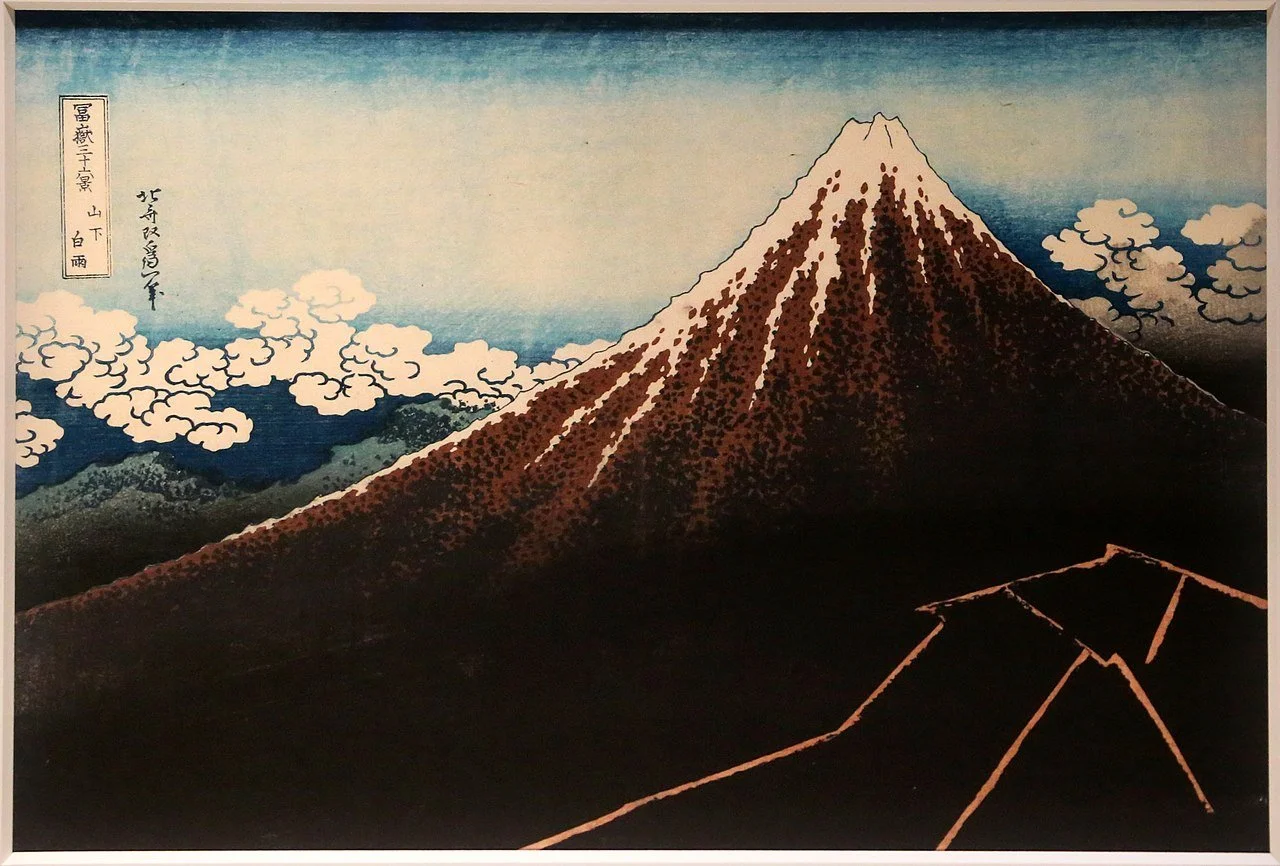 Hokusai woodblock print of Mount Fuji with a snowy peak, white clouds, and lightning near its dark base